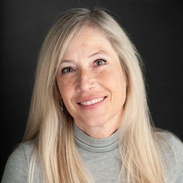Smiling middle-aged woman with long blonde hair and a grey turtleneck.