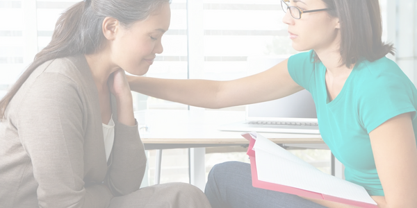 Therapist consoling client experiencing postpartum depression. 
