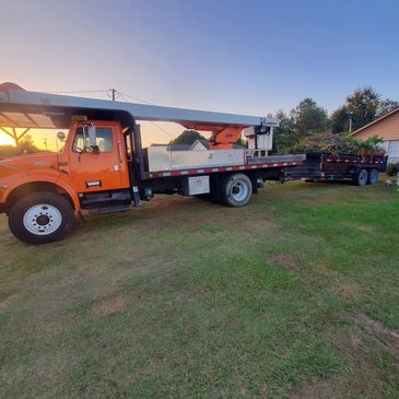 Bucket truck and trailer filled with tree debris.