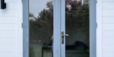 Glass double doors with a view of a cozy living room inside.