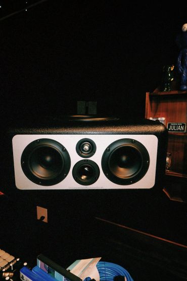 Close-up of a speaker with two large and two small drivers.