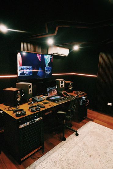 Modern music studio with a laptop and speakers.