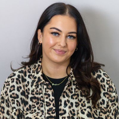 Woman with dark hair wearing a leopard print jacket.