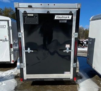 Black Haulmark enclosed trailer with silver trim on a snowy day.