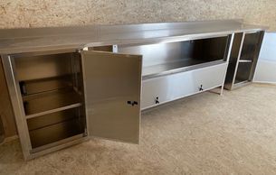 Long stainless steel cabinet with multiple compartments and shelves.