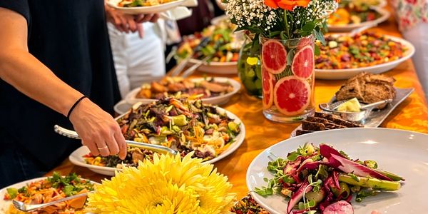 A vibrant buffet table with fresh salads and colorful flowers.