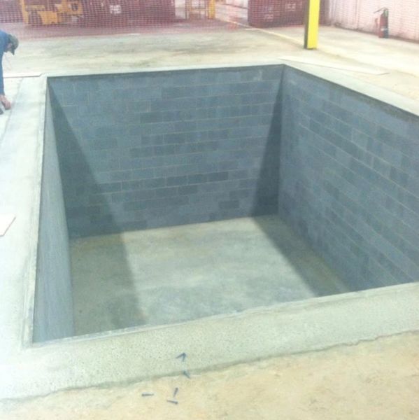 concrete containment pit with cmu walls for chemical vat in an industrial facility