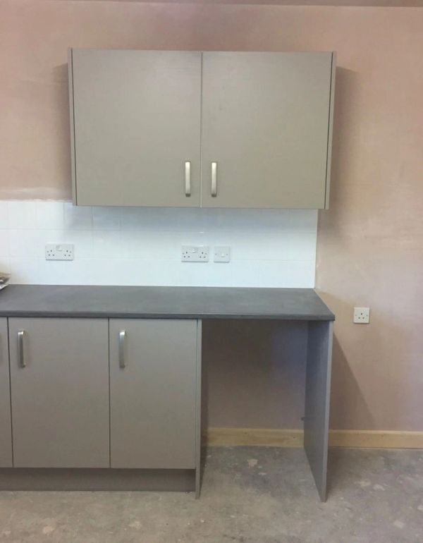 Gray cabinets and countertop in an unfinished room.