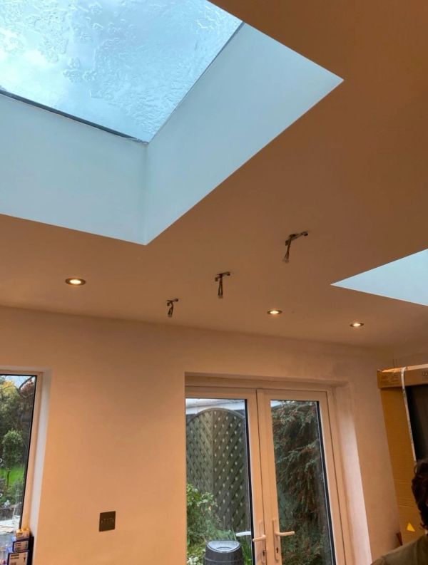 Ceiling with skylights and recessed lights in a room with glass doors.