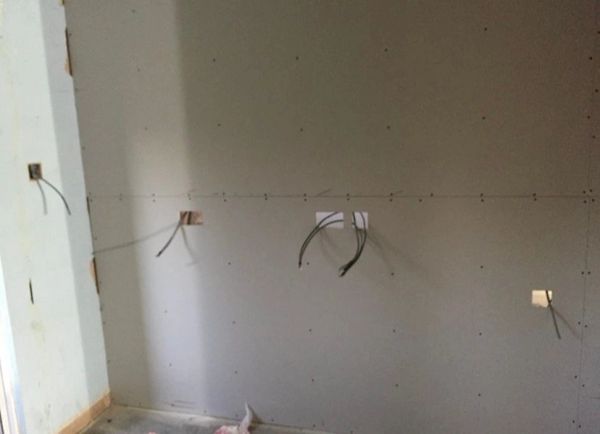 Wall under construction with exposed wiring.