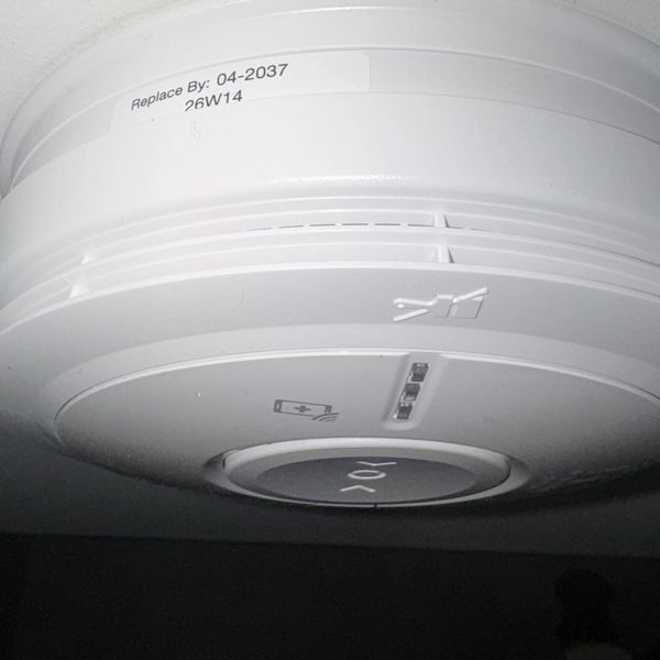 Close-up of a smoke detector with a replace-by date.