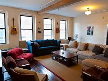 Cozy living room with varied seating and guitars on the wall.