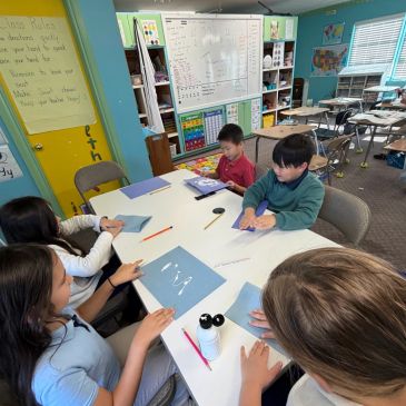 Children engaged in a tactile learning activity with clay at a classroom table.