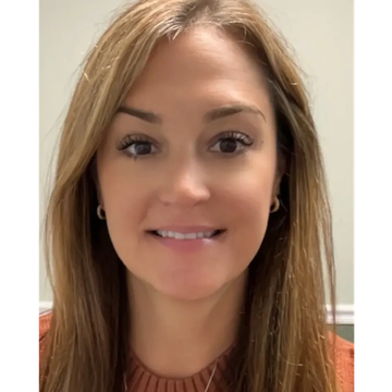 Smiling woman with light brown hair wearing a rust-colored top.