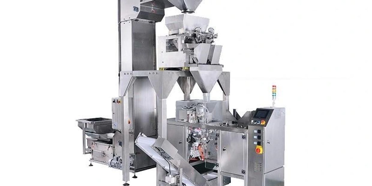 Stainless steel industrial packaging machine with control panel and conveyor.
