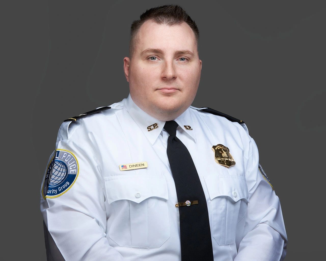 Security officer in uniform with badge and name tag Dineen.
