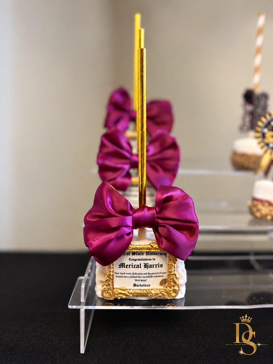 Decorated graduation-themed treats with purple bows and gold accents.