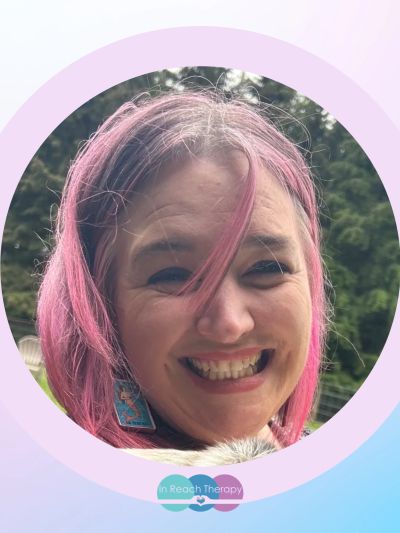 Smiling woman with pink hair outdoors.