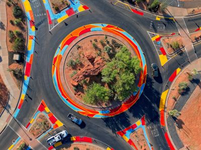 Aerial view of a colorful roundabout with natural greenery in the center.