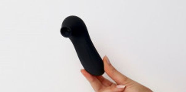 Hand holding back suction sex toy ( Voodoo Beso XOXO)