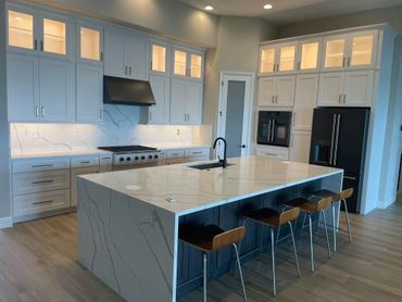 Modern kitchen with large marble island and sleek cabinetry.