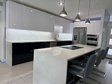 Modern kitchen with white and black cabinetry and a marble island.