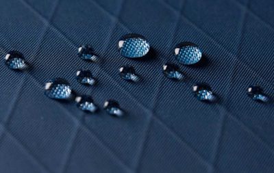 Blue waterproof X-PAC fabric with water droplets beading on fabric
