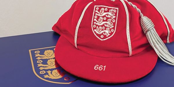 Red cricket cap with the England emblem and number 661.