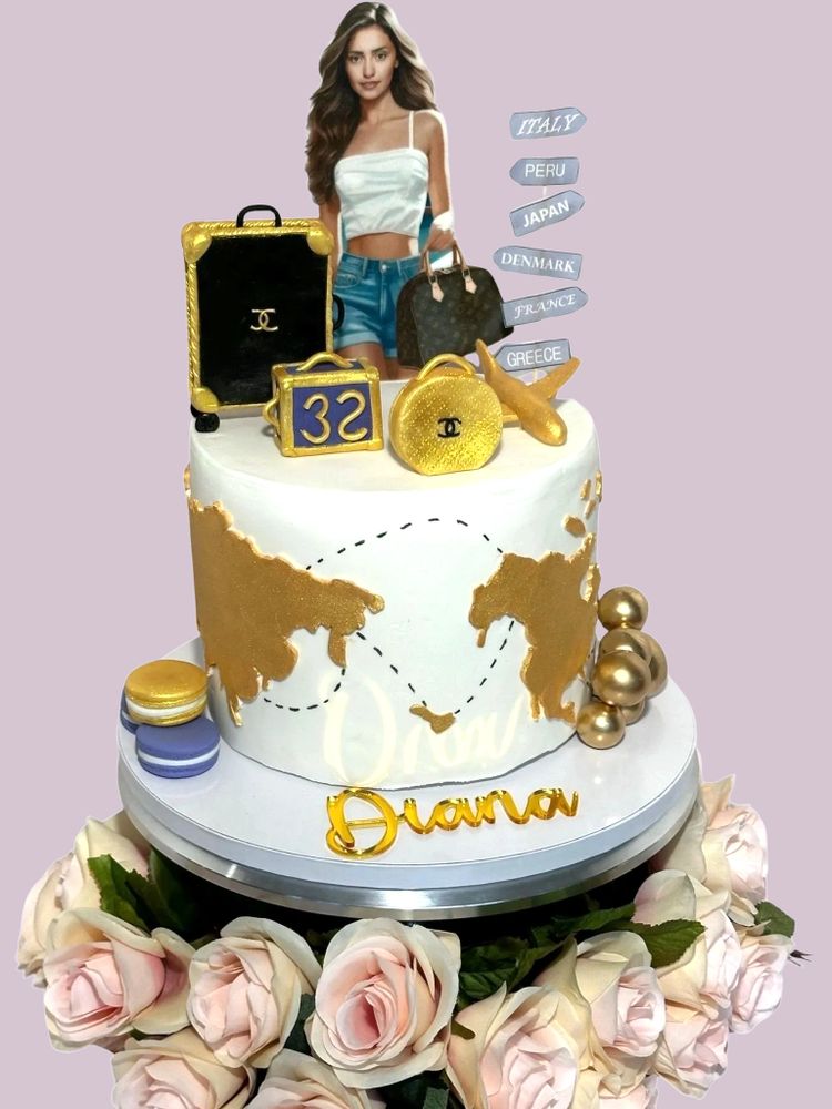 Elegant travel-themed cake with gold accents and a figure of a woman.