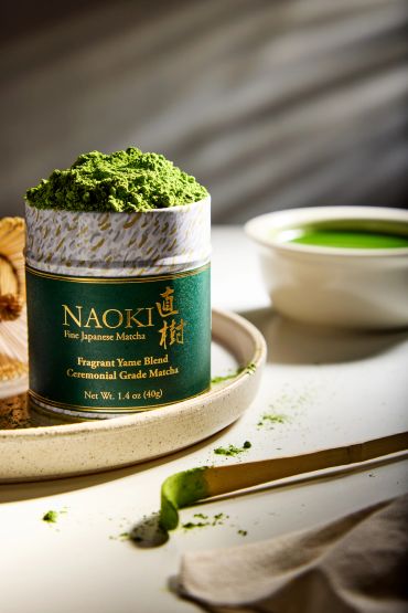 Ceremonial grade matcha powder with a cup of green tea.