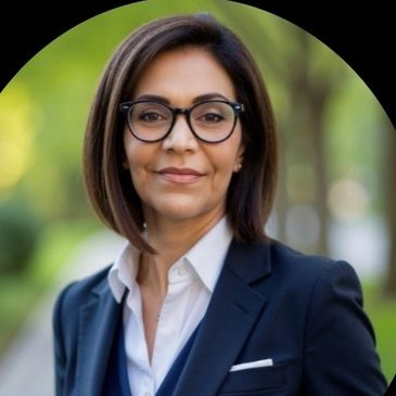 Professional woman in a blazer and glasses outdoors.