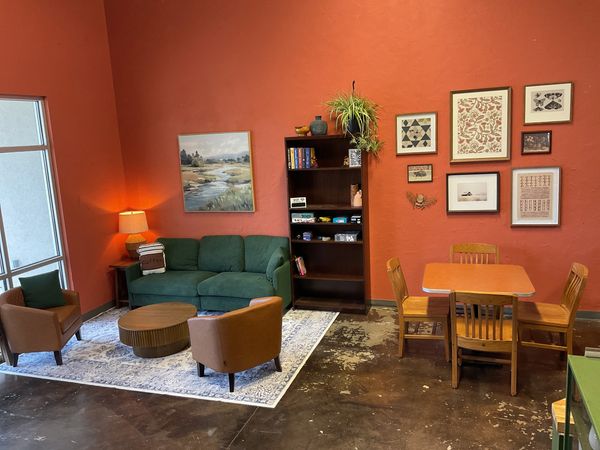 Cozy living room with green sofa and art on walls.