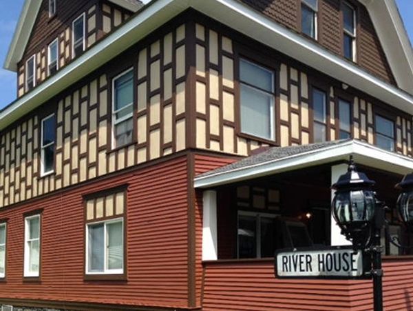 Large, stylish house with unique patterned walls and a 'River House' sign.