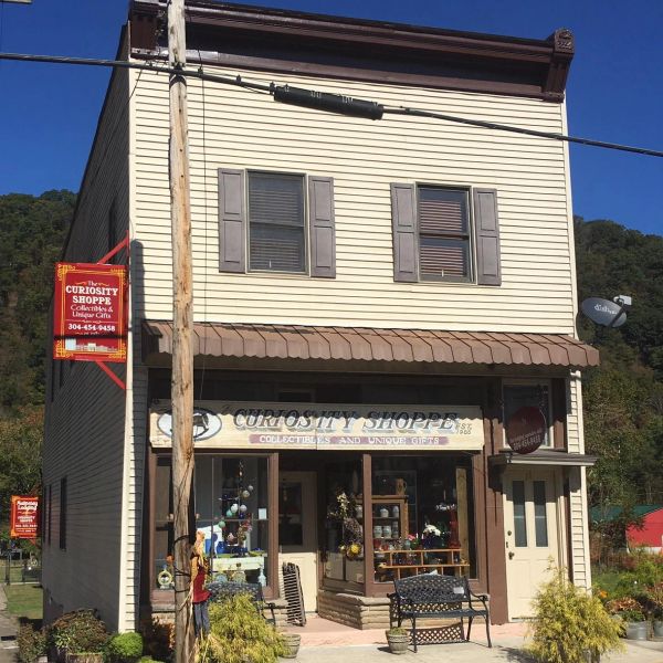 Small-town curiosity shop with vintage charm and outdoor bench.