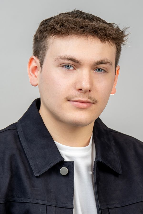 Young man with light mustache and blue eyes.