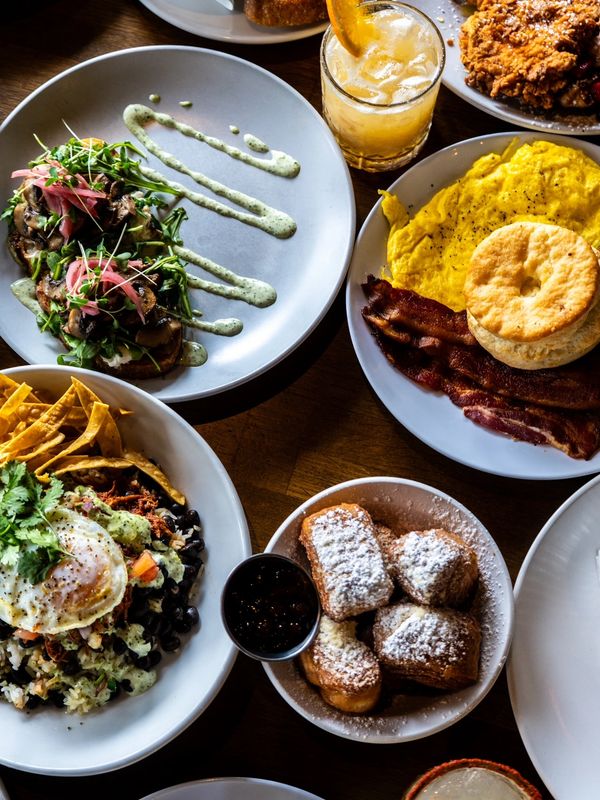 A variety of colorful breakfast dishes arranged on a wooden table.