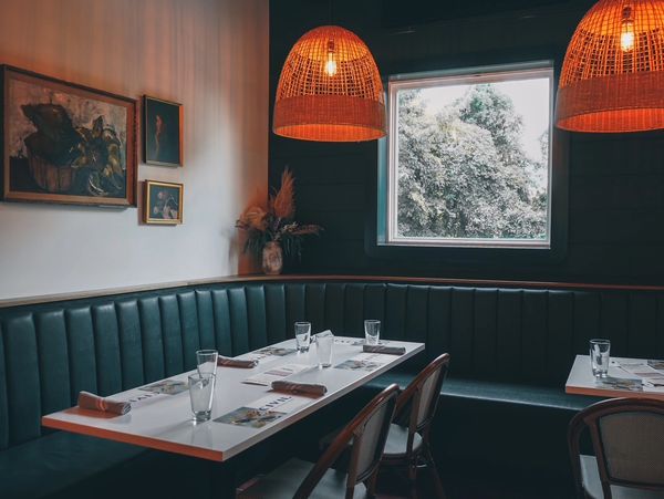 Cozy restaurant corner with warm lighting and green seating.