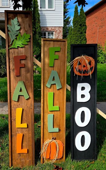 Colorful wooden signs spelling FALL and BOO with autumn decorations.