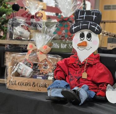 Festive holiday gift baskets and a cheerful snowman doll in cozy attire.