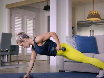 Woman exercising at home with dumbbells