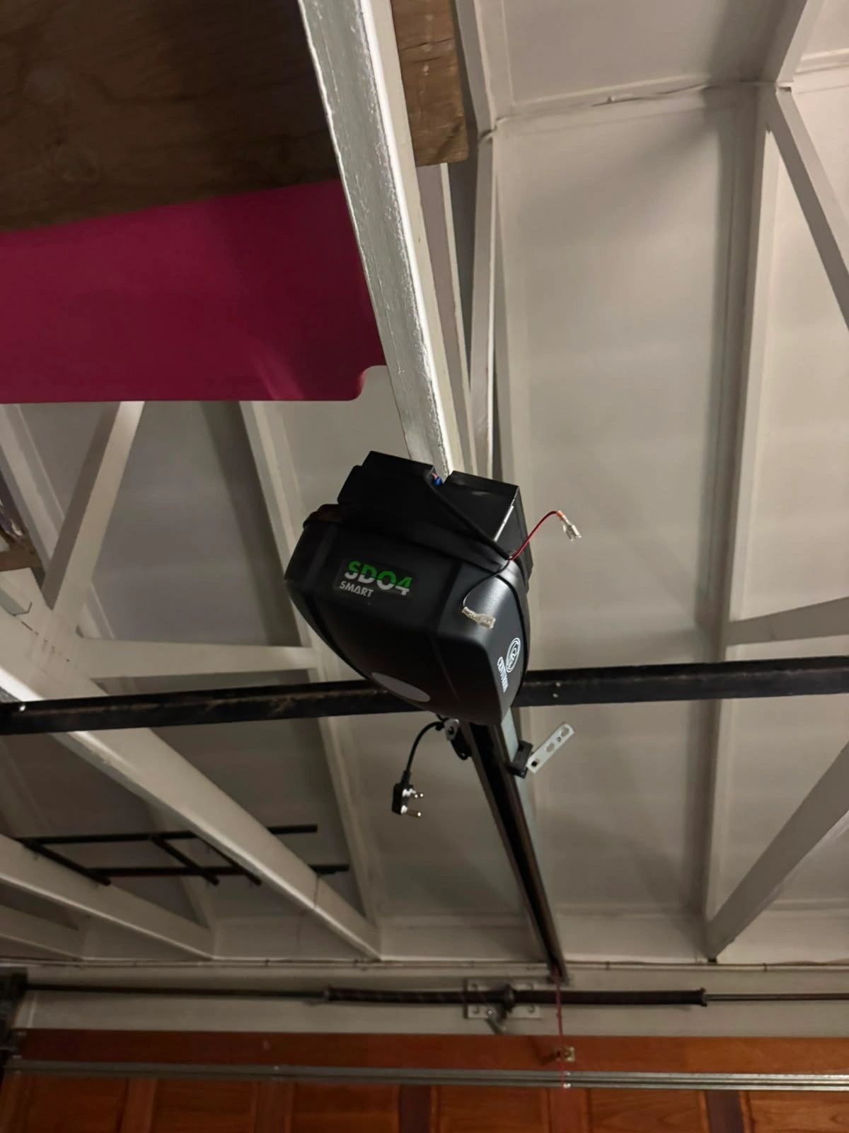 Garage door opener device mounted on ceiling.