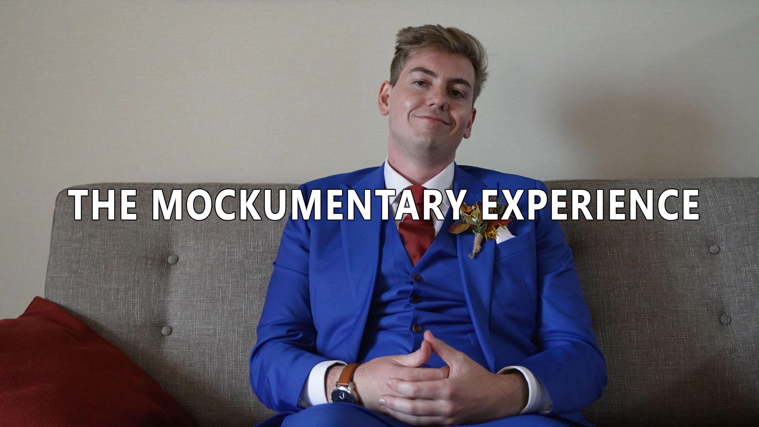 Man in blue suit on grey couch with text "THE MOCKUMENTARY EXPERIENCE".
