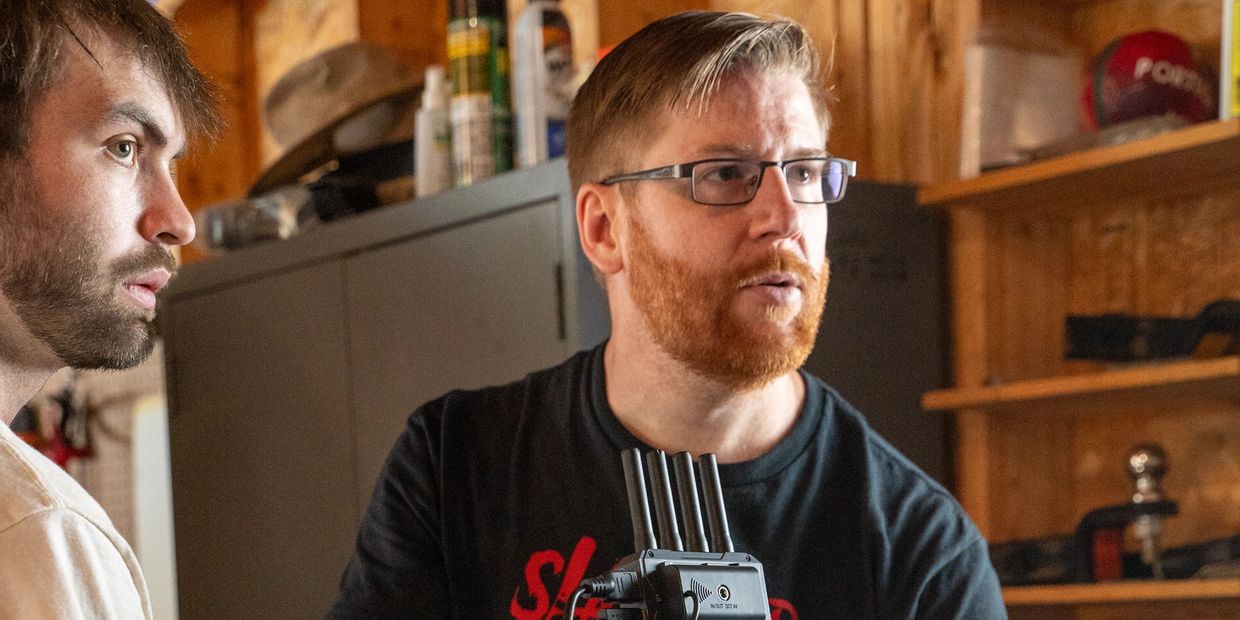 Two men focused on filming with a camera setup.