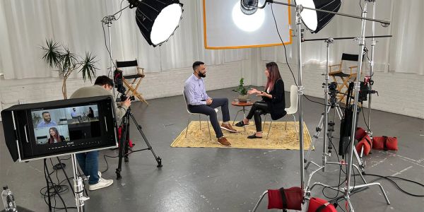 Interview recording setup with two people and camera crew.