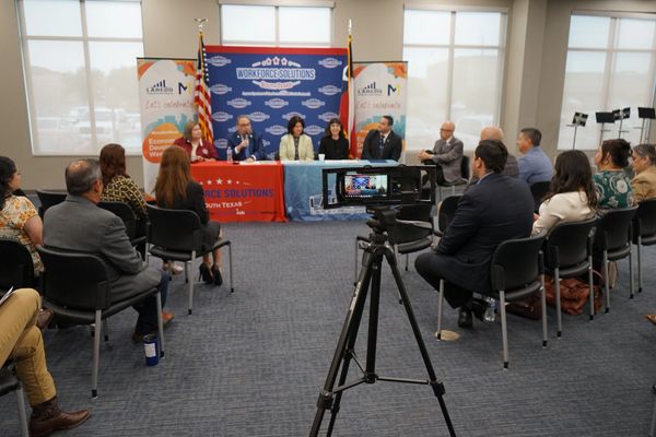 Panel discussion at a workforce solutions event with an audience and camera setup.