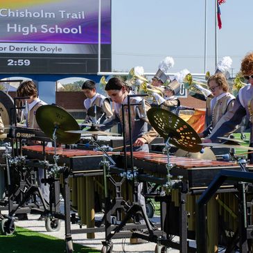 High school marching band performing on percussion instruments.