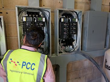 Technician inspecting electrical panels in a utility room.