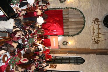 Audience watching a speaker at a festive event in a rustic hall.