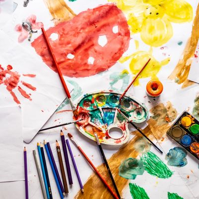 Art supplies and colorful watercolor paintings on paper.
