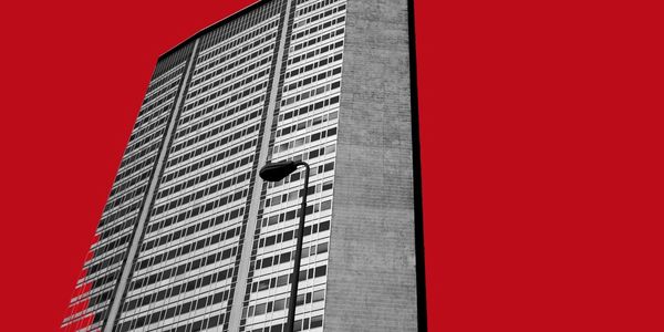 Tall building with a streetlight against a striking red sky.